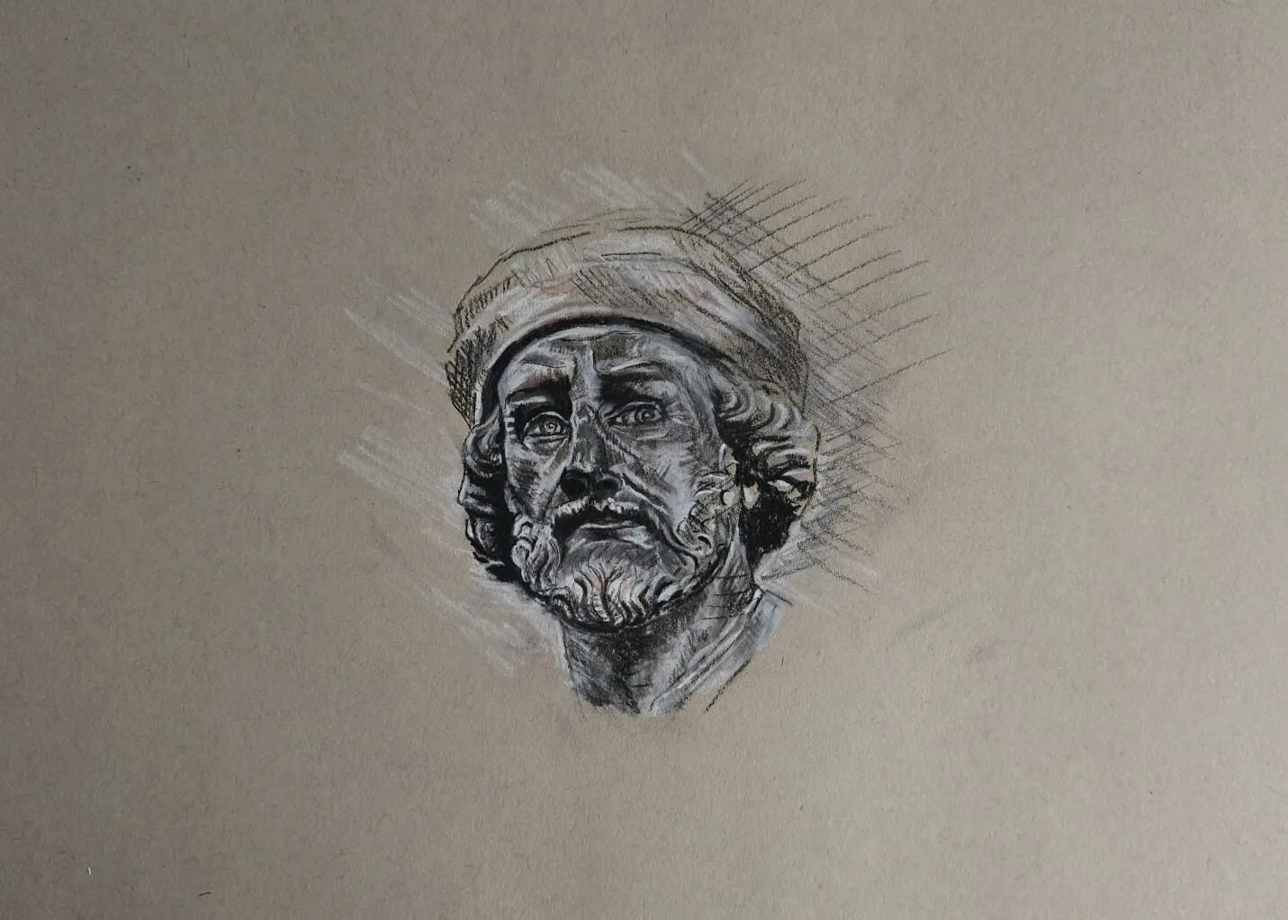 A head study of a bearded man wearing a cap in dark and white pencil on toned paper