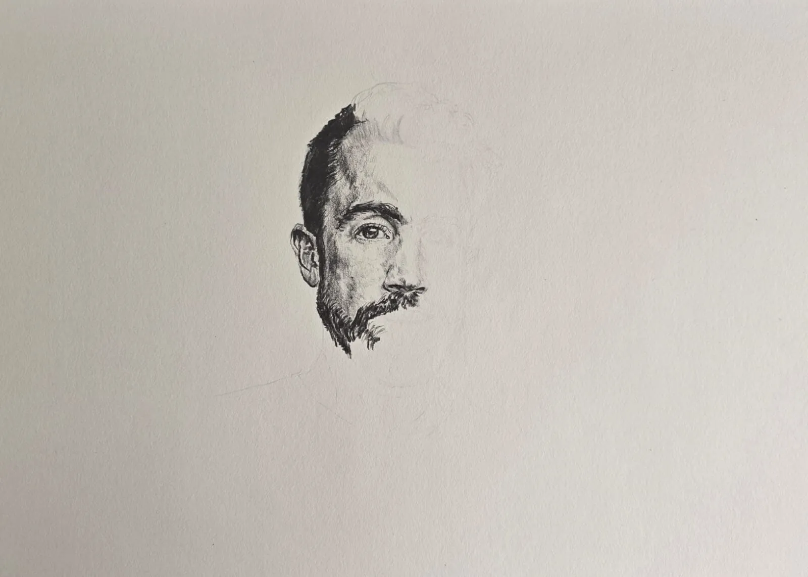 A half-finished graphite portrait study of a man's face