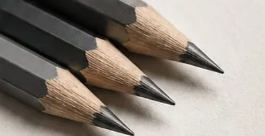 Close-up of sharpened pencils with grey leads on textured paper